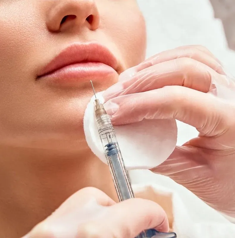 Clinician administering dermal filler injection to patient's lips